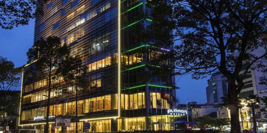 The building shines at night, adorned with bright green lights that enhance its architectural features.